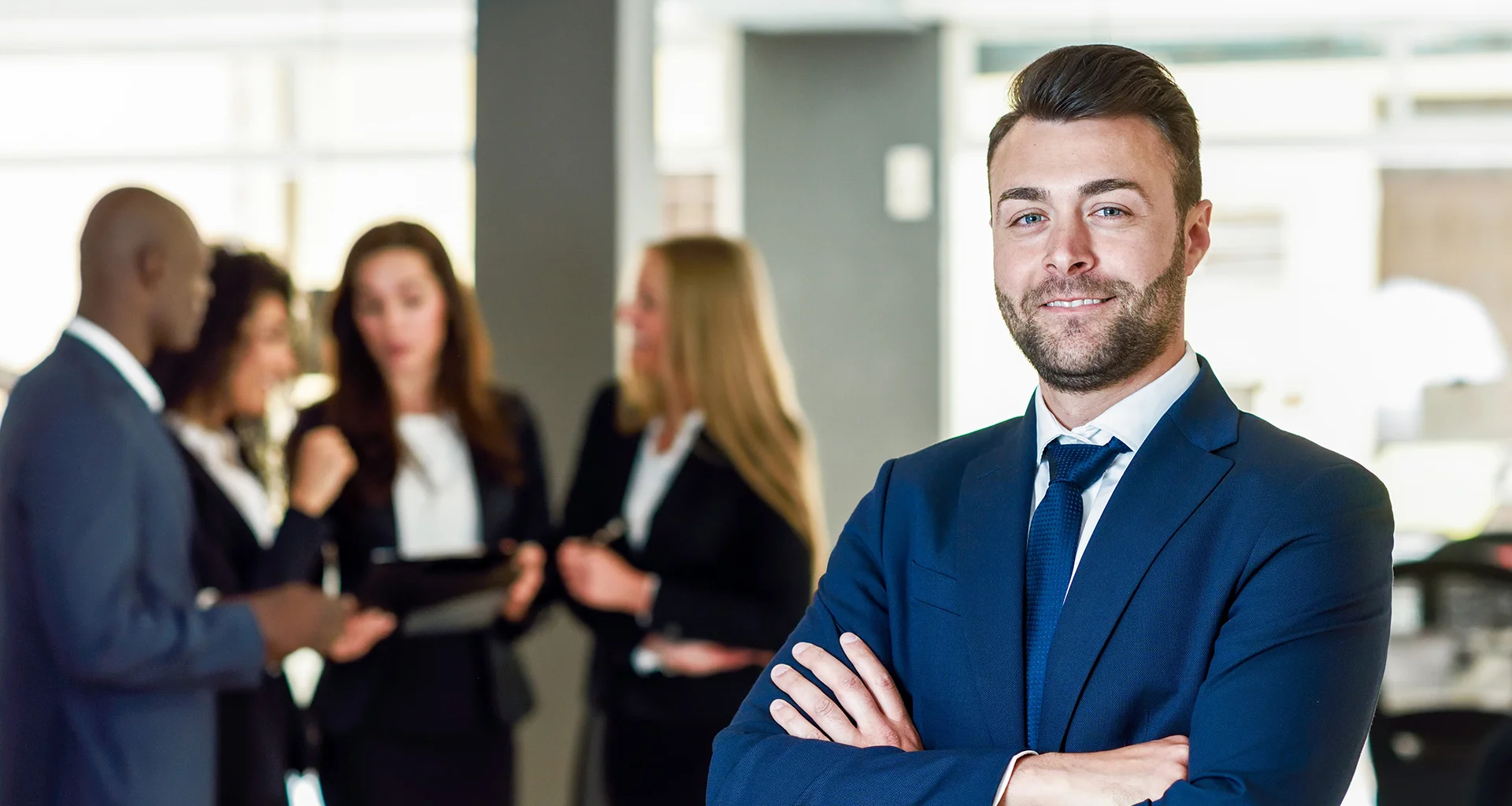 A professional businessman smiling with arms crossed in a bright office setting, illustrating the reliability and customer-focused approach of modern IT and BPO services.