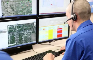 A professional dispatcher wearing a headset managing fleet logistics across multiple computer monitors, highlighting efficient truck dispatch services.